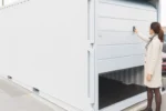 Container di stoccaggio da 20 piedi con apertura a porta sezionale da garage.